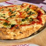 Nas fotos do artigo, adicione descrições ricas como: "pizza napolitana artesanal assada no forno ooni com borda alta e pesto