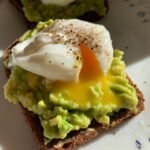 Aprenda como fazer o Avocado Toast com Ovo Pochê perfeito! Descubra o truque infalível para a gema escorrer e dicas de variações saudáveis.