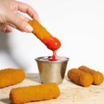 enroladinho frito mergulhando no molho de tomate