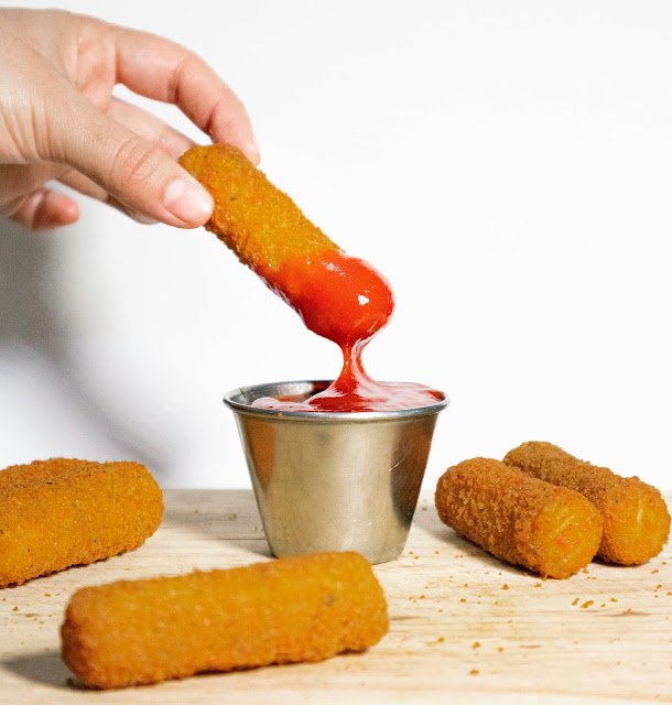 enroladinho frito mergulhando no molho de tomate