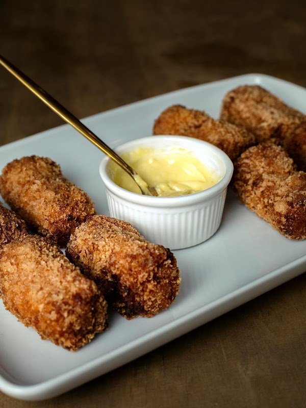 Bolinho de carne seca crocante servido em prato