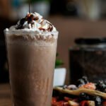 Descubra como fazer uma mousse três chocolates cremosa com pipoca de caramelo e uísque! Uma sobremesa simples, elegante e irresistível.
