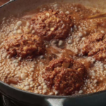 Almôndegas caseiras de carne moída cozinhando em molho de tomate temperado na panela.