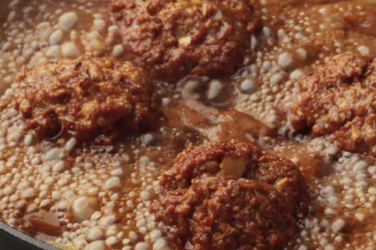 Almôndegas caseiras de carne moída cozinhando em molho de tomate temperado na panela.
