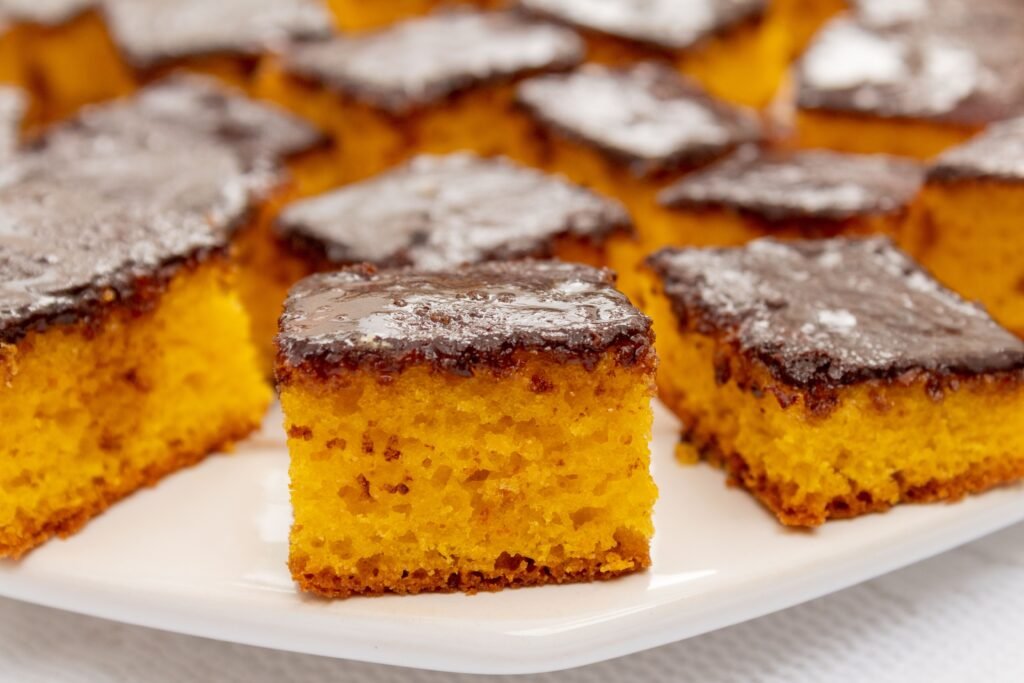 Bolo de cenoura fofinho com cobertura de chocolate durinha cortado em quadrados