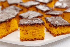 Bolo de cenoura fofinho com cobertura de chocolate durinha cortado em quadrados