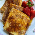 Rabanadas douradas com açúcar e canela, preparadas com pão amanhecido.