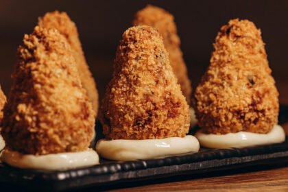 Coxinhas cremosas de frango sem massa tradicional, empanadas e douradas, servidas como petisco.