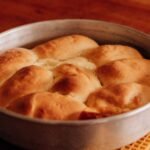 Pão caseiro de abóbora macio, modelado em formato de abóbora e assado até dourar.