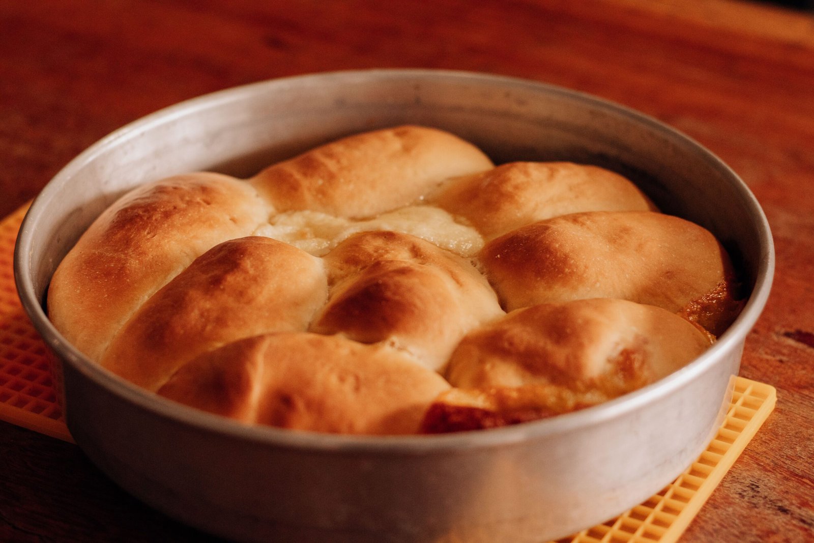 Pão caseiro de abóbora macio, modelado em formato de abóbora e assado até dourar.