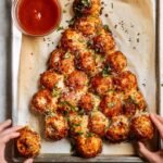 Pão de alho puxa-puxa em formato de árvore de Natal, com bolinhas douradas, queijo parmesão, ervas e molho para acompanhar.
