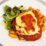 Filé de frango empanado à parmegiana com molho de tomate e queijo gratinado.