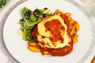 Filé de frango empanado à parmegiana com molho de tomate e queijo gratinado.