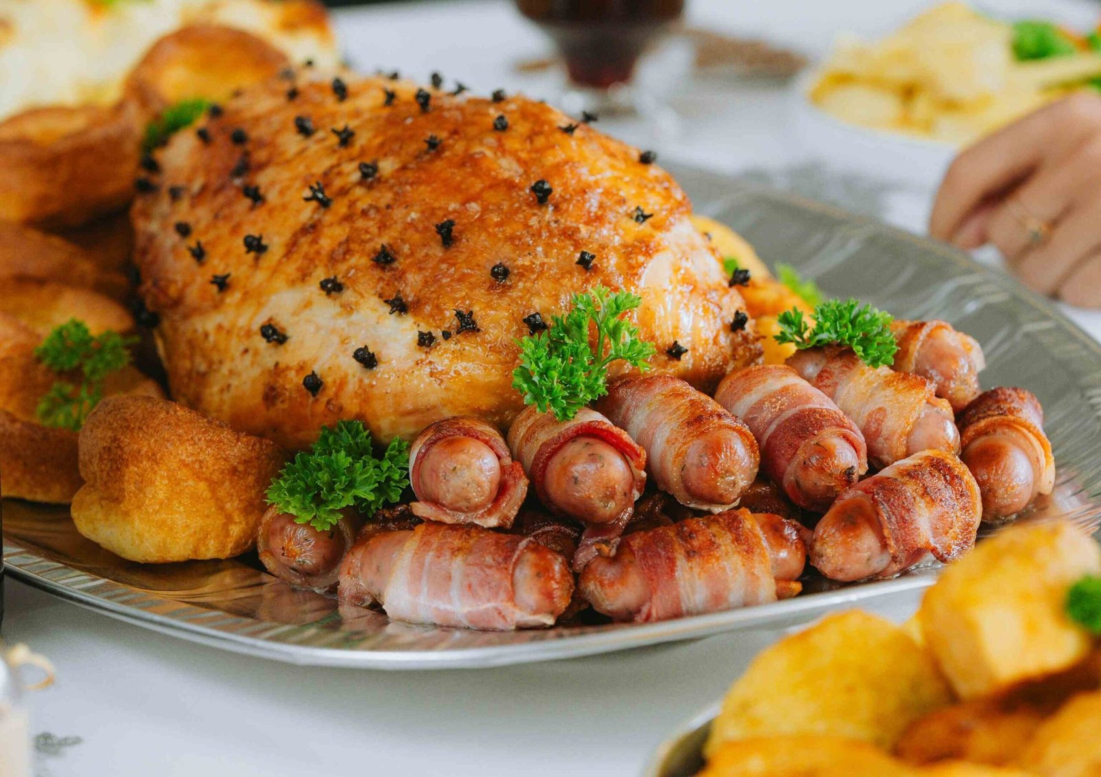 Mesa de ceia de Natal simples com pratos caseiros, acompanhamentos, bolo e bebida festiva.